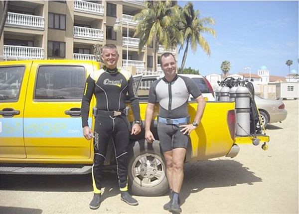 In this Nov. 11, 2009 photo provided by Dick de Bruin, was taken with his camera and shows de Bruin, left, and Toine van der Klooster, both members of  the Royal Dutch Navy, preparing to scuba dive as part of a dive team that was salvaging an anchor from the USS Powell for a World War II memorial in Aruba. De Bruin's camera floated away from him during the dive and was found months latter in Key West, Fla. (AP Photo/Courtesy of Dick de Bruin)